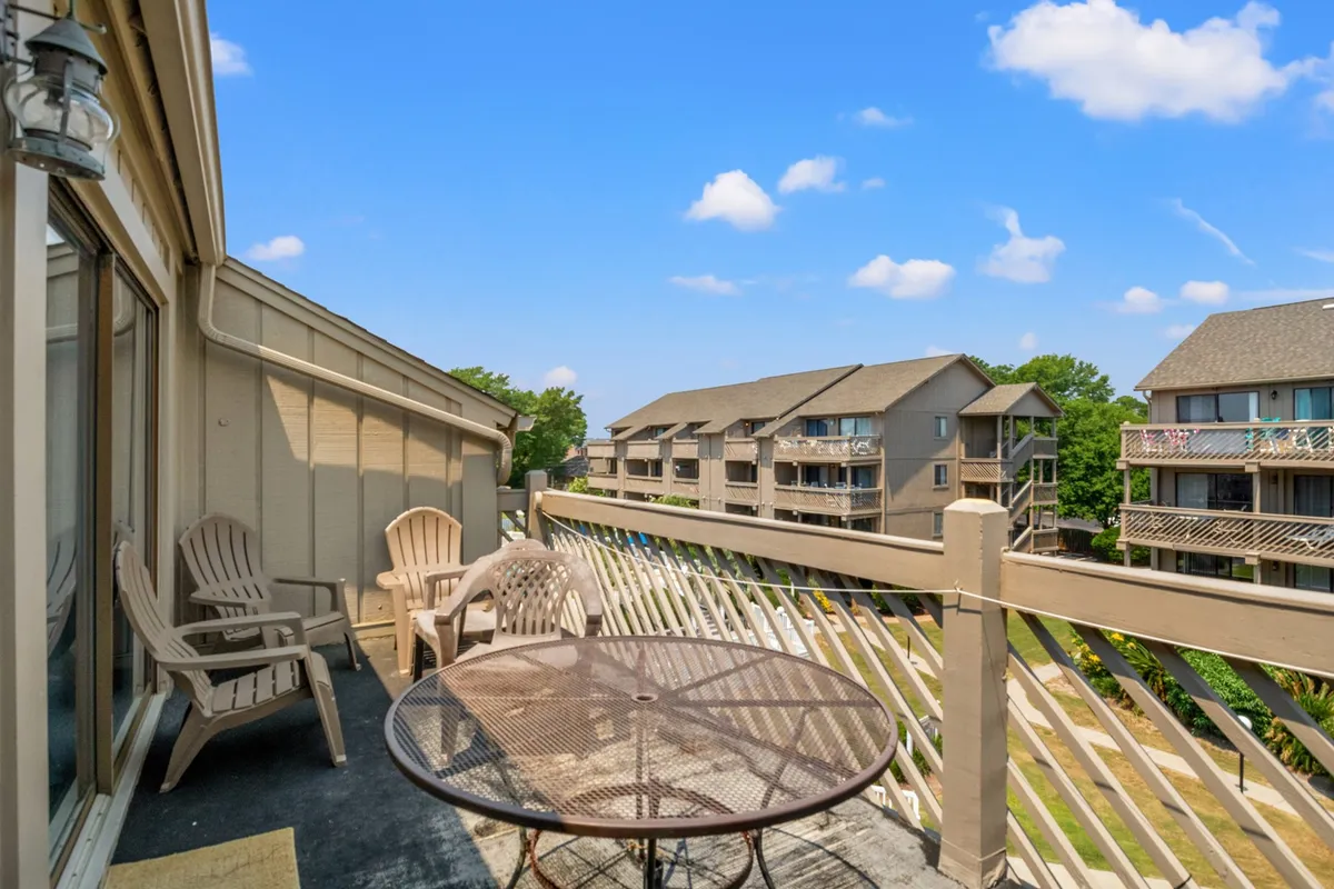A tranquil outdoor seating area surrounded by lush greenery and adjacent buildings, featuring a dining table ideal for meals, reading, or quiet relaxation. The scene radiates casual comfort and opportunities to enjoy Myrtle Beach’s mild winter climate.